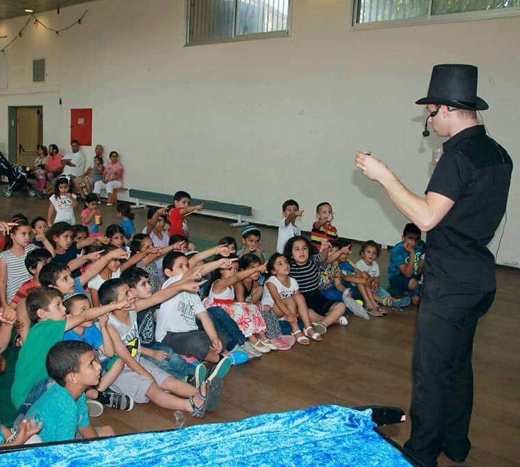 ילדים מרותקים למופע הקסמים של לול הקוסם
