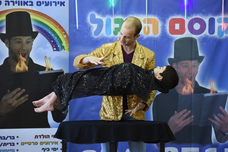 לול הקוסם מעיף ילד באוויר במופע יום הולדת